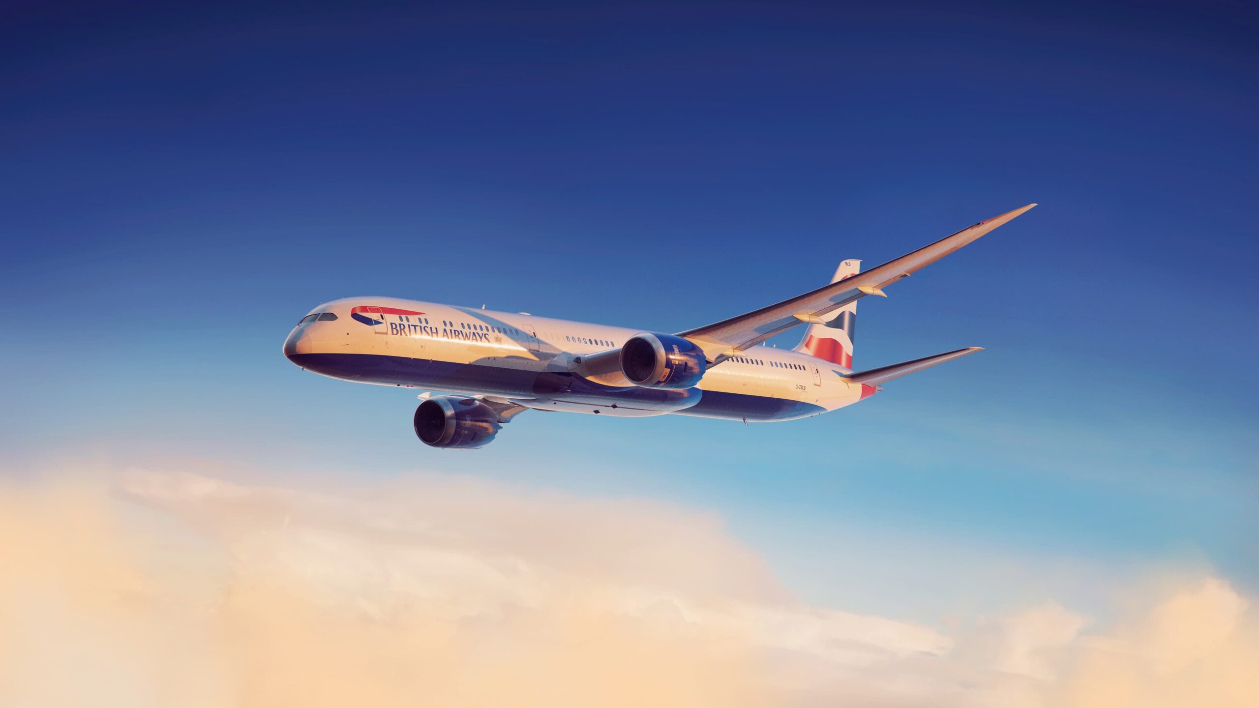 Image shows the side view of a British Airways Boeing 787-10 aircraft in-flight in a blue sky with pinkish clouds underneath
