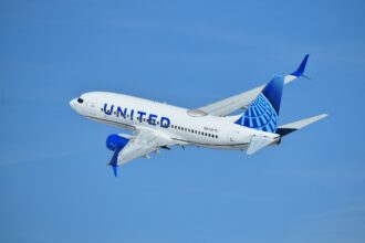 United Airlines plane flying in the blue sky