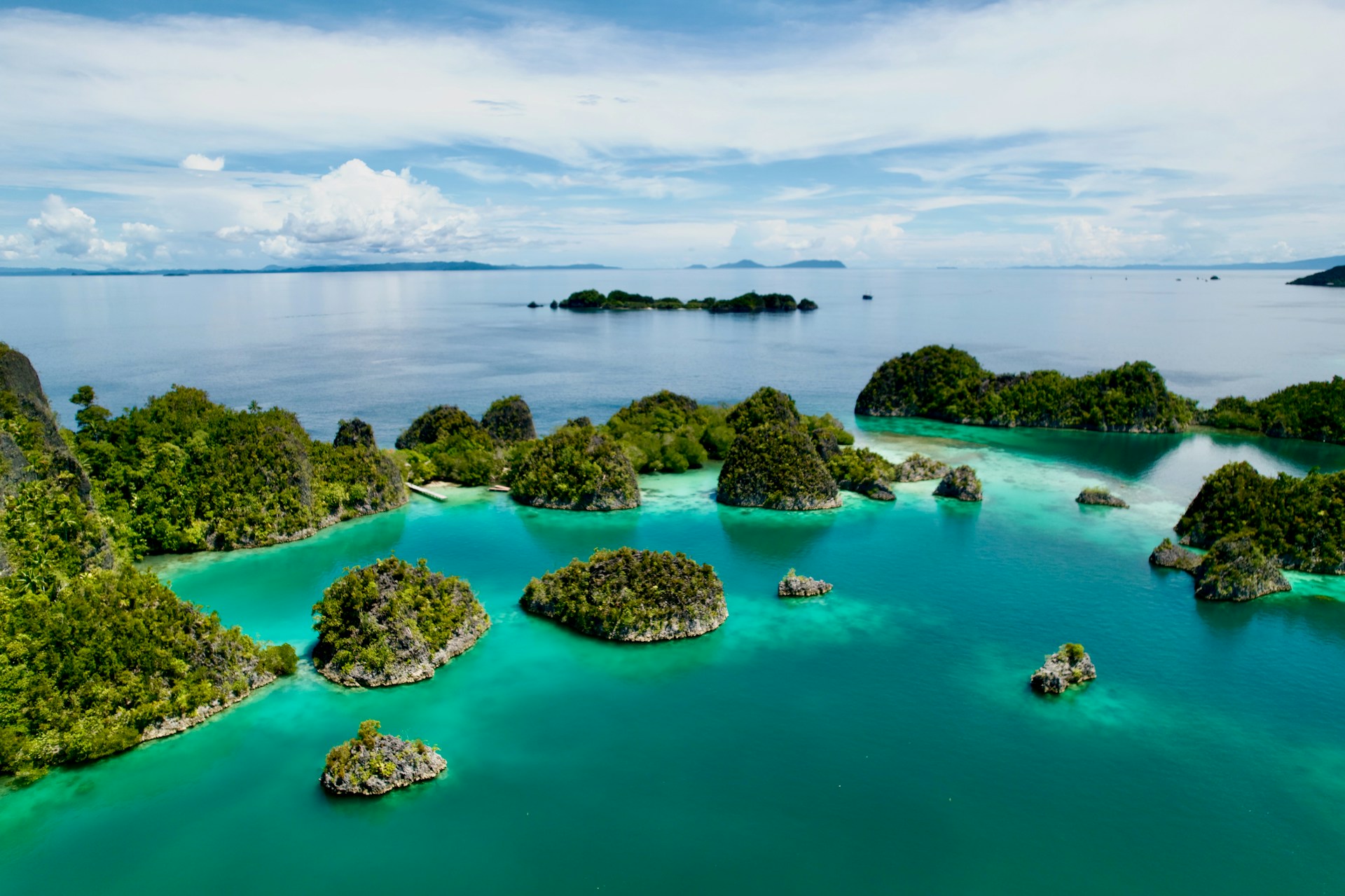 Islands close together in turquoise waters in Raja Ampat, Indonesia