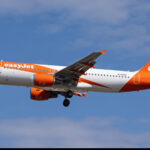 An easyJet Airbus A320 approaching an airport with its landing gear lowered