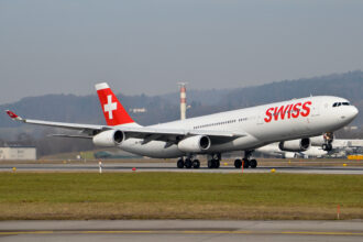 Photograph depicting Swiss Airbus A340 taking off from the airport runway.