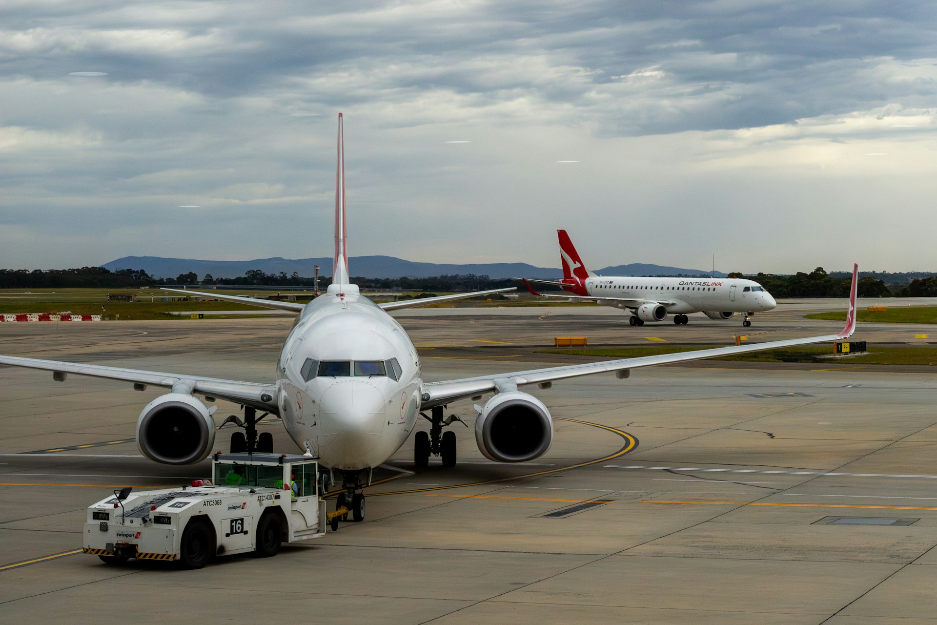 Plane in runway with a Qantas plane in the back