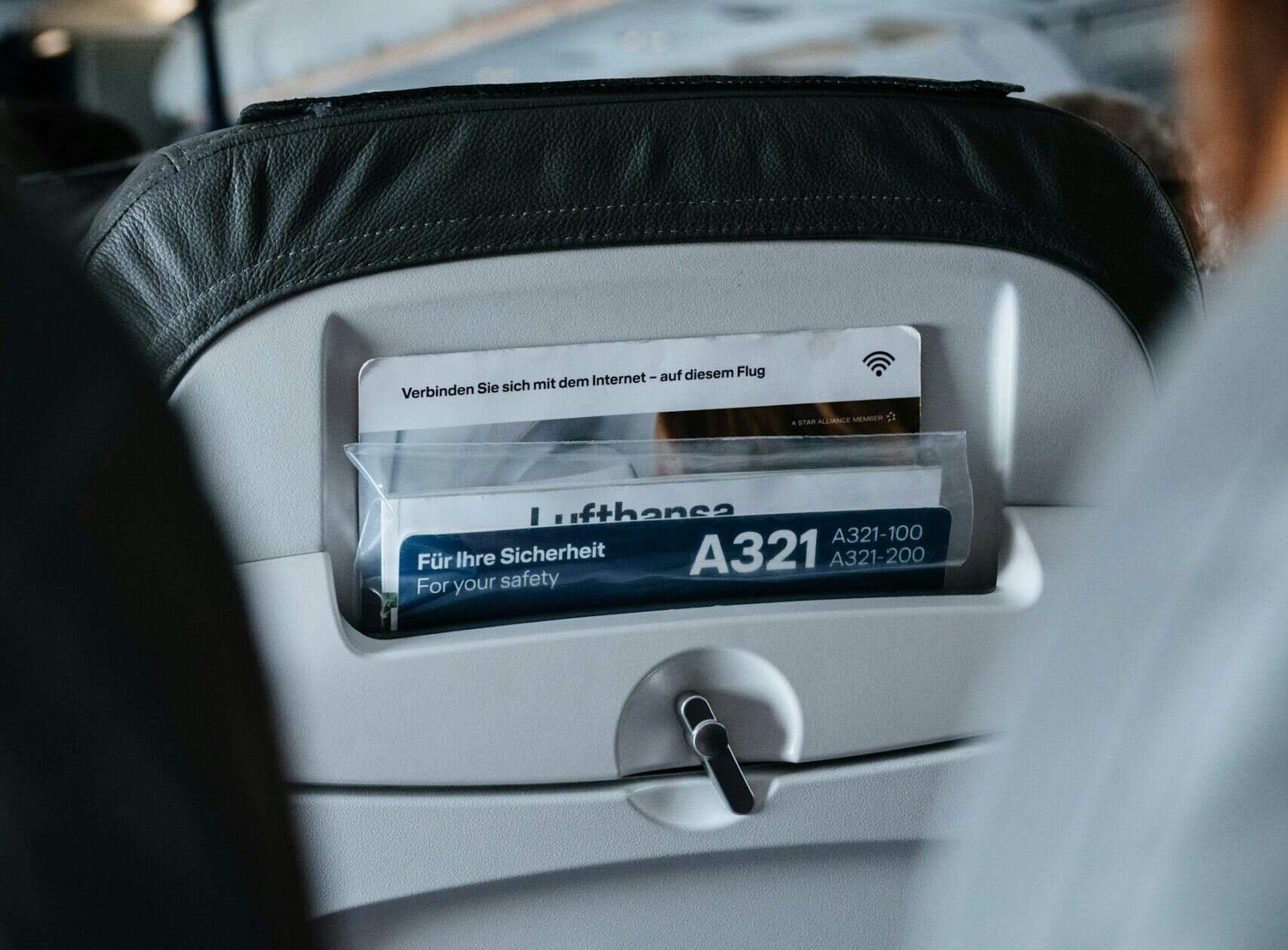 The inside of a Lufthansa aircraft with passenger information booklet 