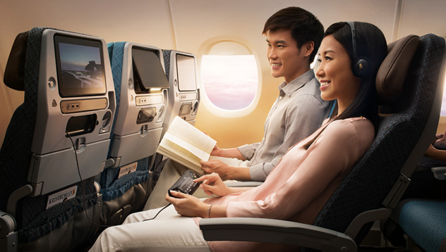 Photograph depicting passenger seated in Singapore Airline's new economy class in front of the in-flight entertainment screen.