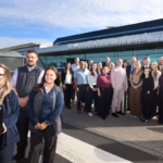 An image of a group of Newcastle Airport employees posed outside of the terminal at Newcastle Airport with their 'Airport of the Year' in the hands of the employee at the front of the group.
