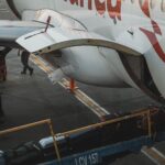 Ground crew loading baggage into the cargo hold of a passenger aircraft