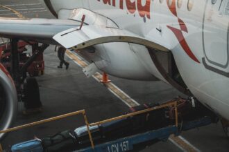Ground crew loading baggage into the cargo hold of a passenger aircraft