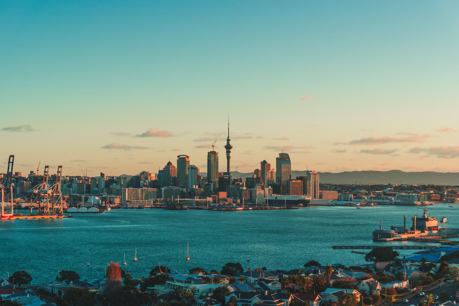 View of Auckland with buildings and water body with blue sky and sunset hues in the background