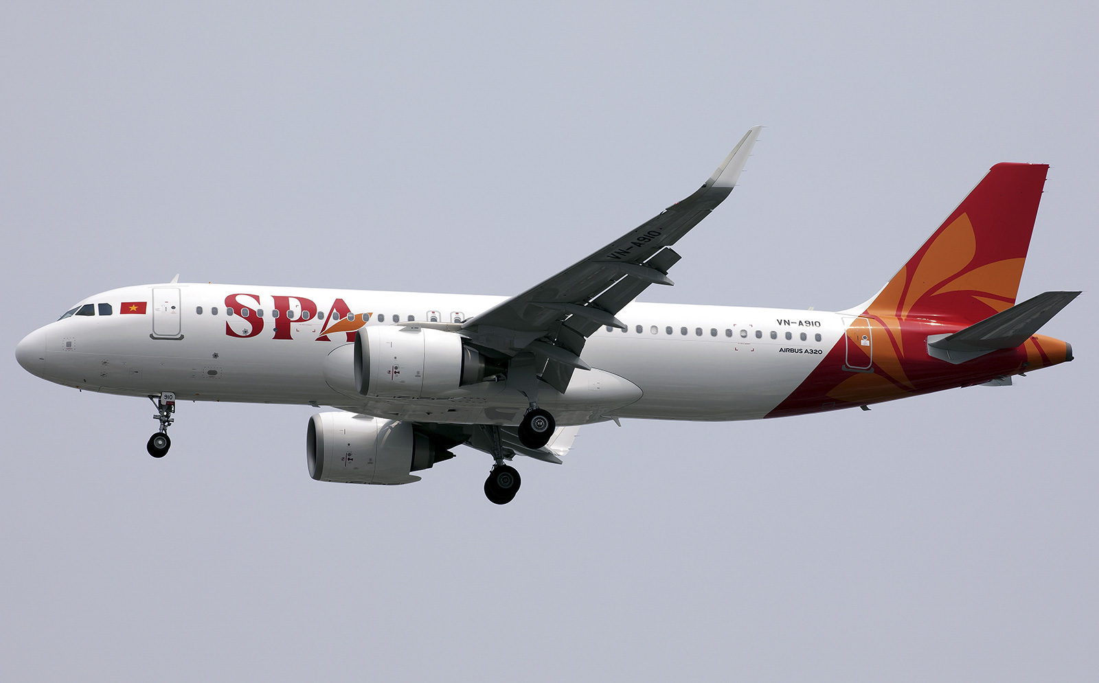 An image of a Sun PhuQuoc Airways A320 plane mid-flight, with a grey sky as the background. 