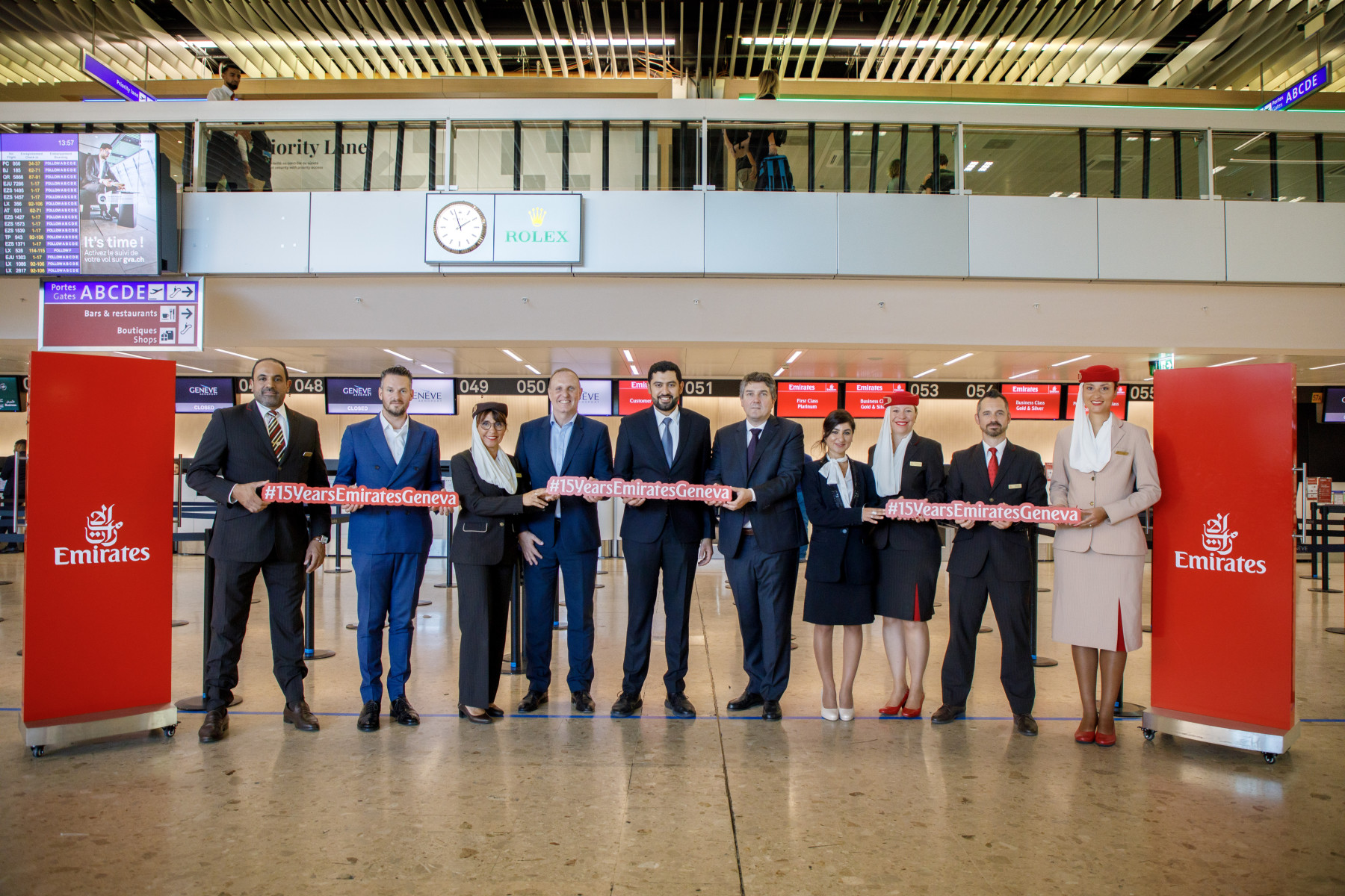 Photograph depicting a red ribbon ceremony for Emirates staff celebrating 15 years of flying between Dubai and Geneva. 