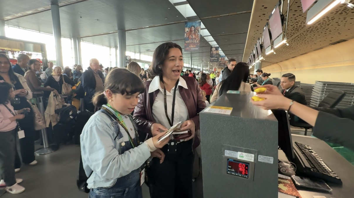 Photograph depicting a woman with Autism as identified by the sunflower lanyard, preparing for the Emirates travel rehearsal in an airport in Colombia and accompanied by another woman.