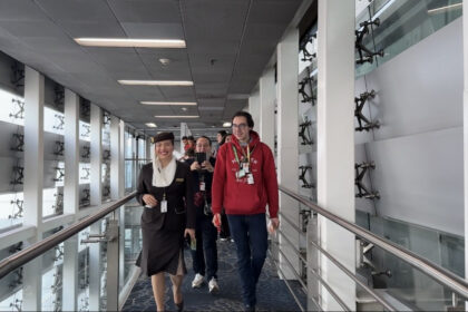 Photograph depicting an individual with Autism, wearing a sunflower lanyard to represent invisible disabilities, preparing to board the aircraft.