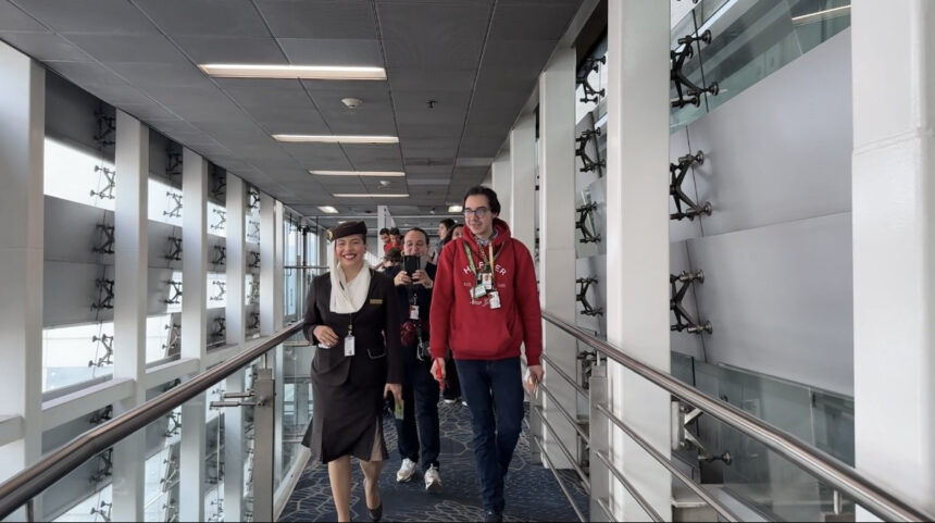 Photograph depicting an individual with Autism, wearing a sunflower lanyard to represent invisible disabilities, preparing to board the aircraft.