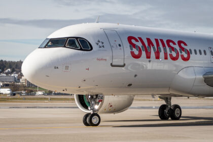 Photograph depicting the front aspect of SWISS A320 Neo aircraft, including a view of the cockpit and wheels, when the aircraft is on the airport runway.