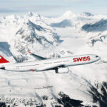 Photograph depicting a SWISS Airbus A330-300 flying above a snowy and mountainous landscape.