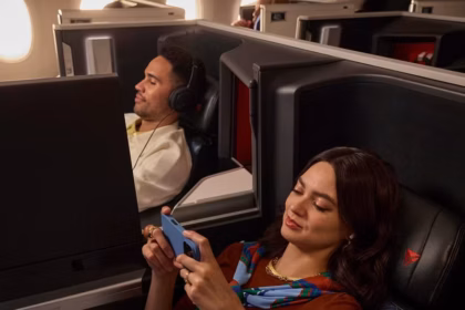 Two people on a Delta flight sitting in Delta One premium seats.
