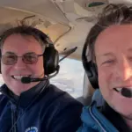Jamie Oliver (right) learning to fly. He is sat in an aircraft with an instructor from Andrewsfield Aviation.