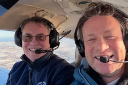 Jamie Oliver (right) learning to fly. He is sat in an aircraft with an instructor from Andrewsfield Aviation.