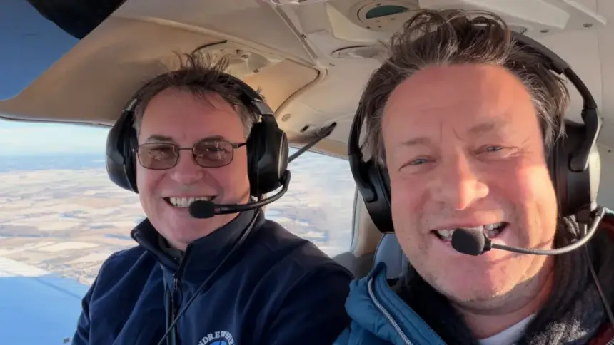 Jamie Oliver (right) learning to fly. He is sat in an aircraft with an instructor from Andrewsfield Aviation.
