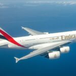 Photograph depicting Emirates A380 flying high above the clouds.