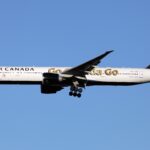 White aircraft flying against a cloudless blue sky