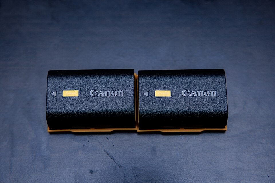 Photographed is a. Canon LP-E6NH battery pack in a black background