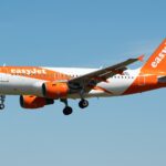 An easyJet Airbus A319-111 taking off from Barcelona El Prat (BCN / LEBL) with its landing gear still extended.
