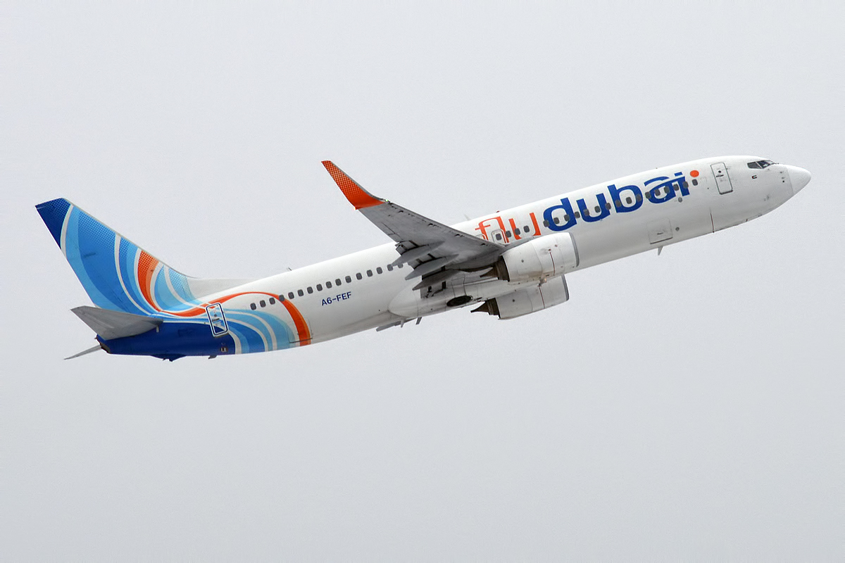 Image shows a Flydubai aircraft mid flight. It has a blue and orange livery 