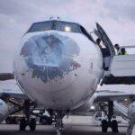 Damages on the front of the Yemenia Airways aircraft with a dent in the front. Staff situated on the side of the aircraft trying to assess the situation