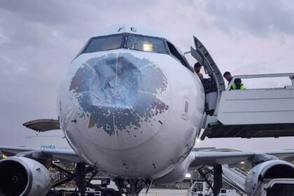 Damages on the front of the Yemenia Airways aircraft with a dent in the front. Staff situated on the side of the aircraft trying to assess the situation