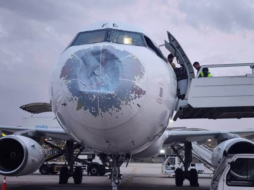 Damages on the front of the Yemenia Airways aircraft with a dent in the front. Staff situated on the side of the aircraft trying to assess the situation
