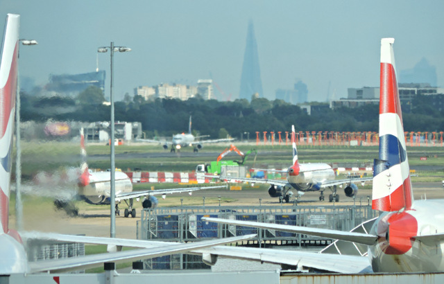 Image shows Heathrow Airport, with a plane in the foreground and The Shard in the background