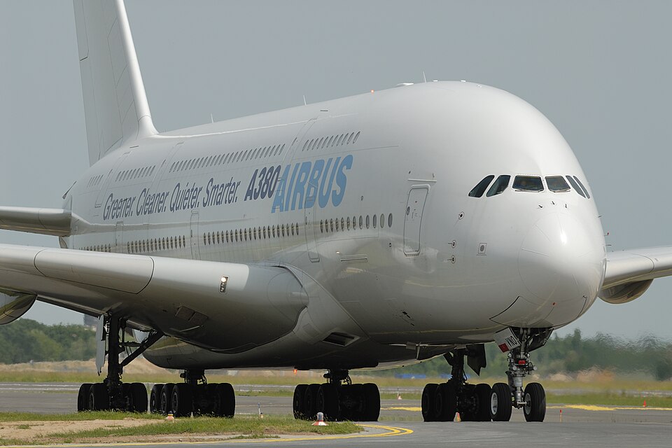 Image shows an Airbus A380 test livery aircraft taxiing at an airport after landing on a grey day