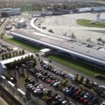 An aerial view of London Southend Airport (SEN). A car park is shown on one side of the airport terminal, with runways and grassy areas on the other.
