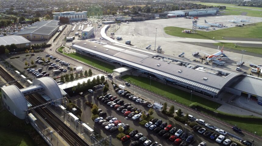 An aerial view of London Southend Airport (SEN). A car park is shown on one side of the airport terminal, with runways and grassy areas on the other.