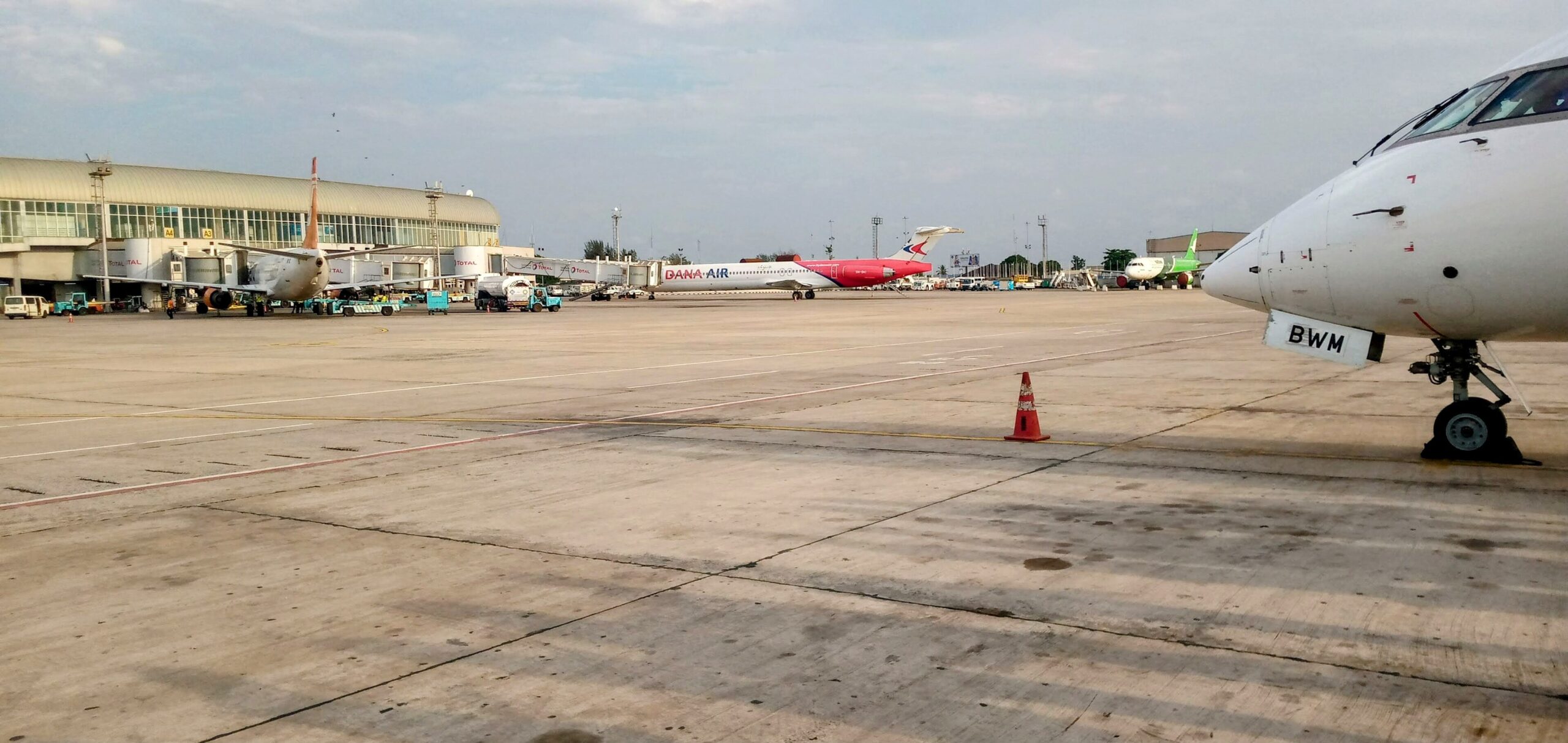 A jet’s white nose cone can be seen in front of Murtala Muhammed International Airport (LOS). The jet is sat on a runway.