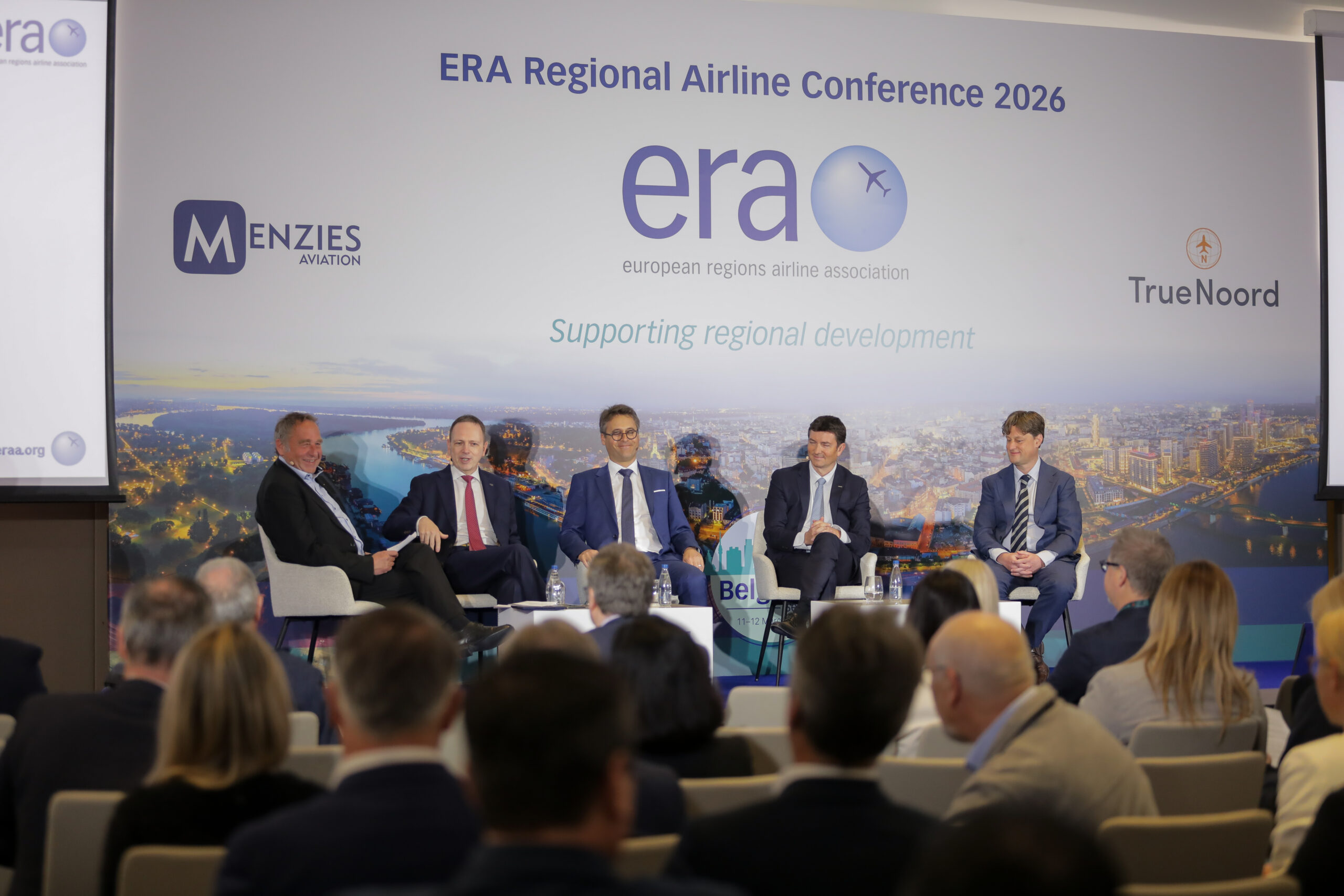 A group of five speakers sat on a stage in front of branding for the European Regions Airline Association.