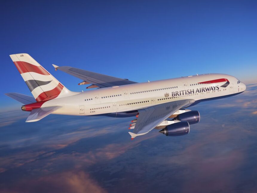 A red, white, and blue, British Airways jet flying over a layer of cloud.