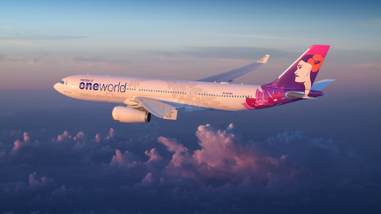 A white and purple jet in the livery of the Oneworld airline alliance flying over some clouds.