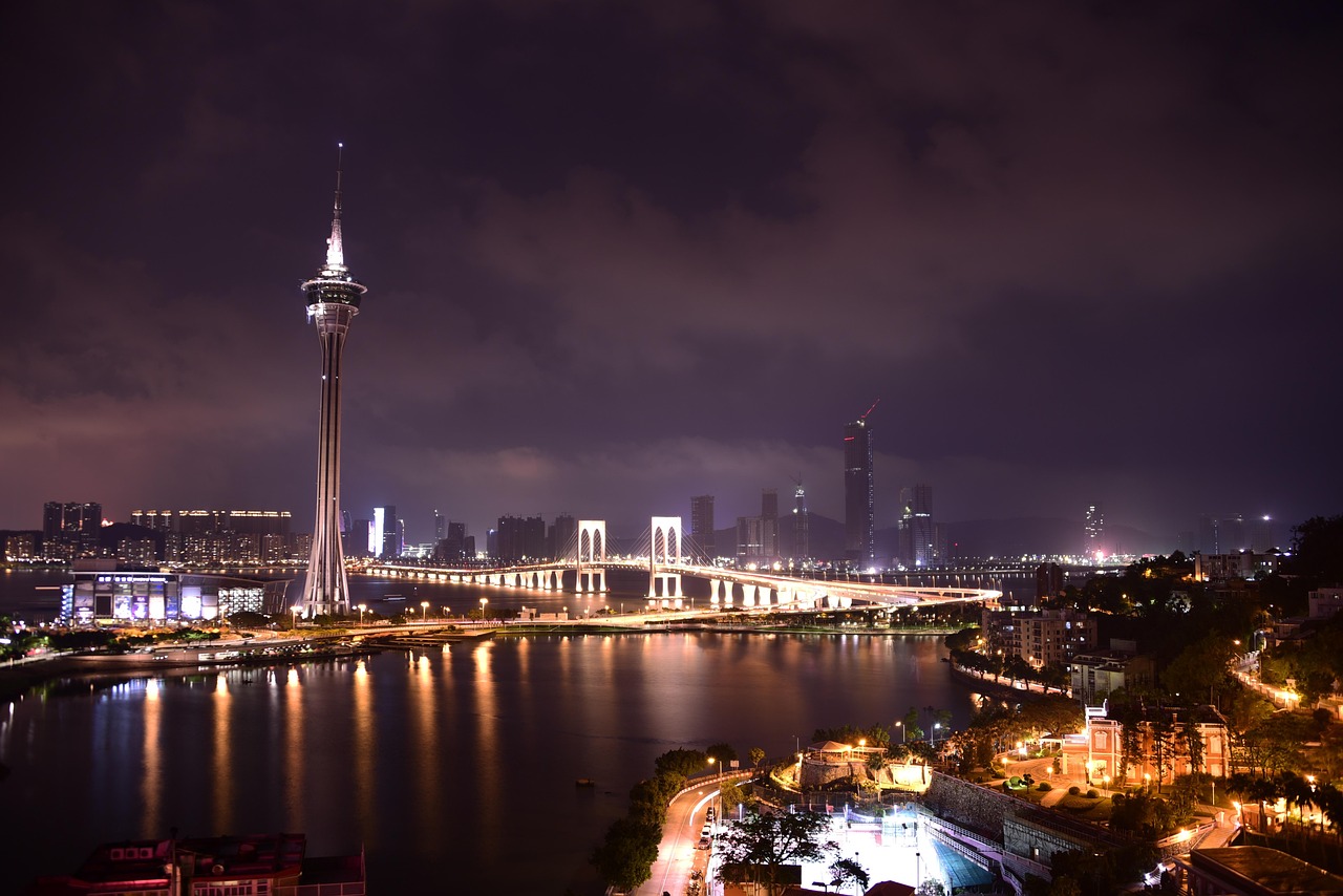 A view of the city of Macau at night, the Macau Tower is lit up brightly.