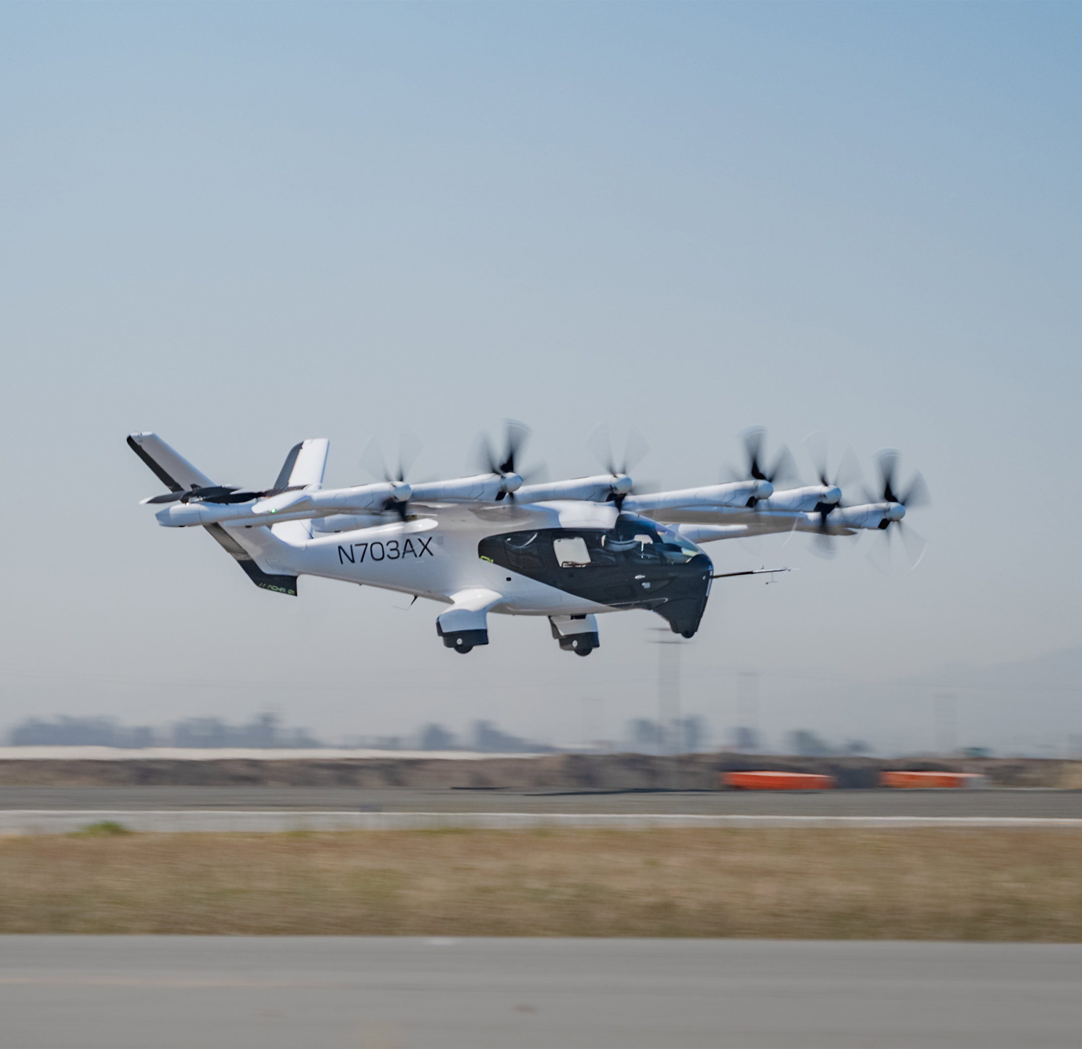 A black and white Archer Midnight aircraft landing on an airport runway.