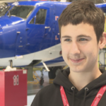 Dmytro Miskov standing in front of an aircraft in Loganair's mechanic workshop.