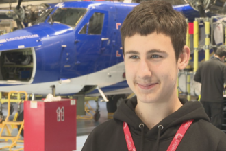 Dmytro Miskov standing in front of an aircraft in Loganair's mechanic workshop.