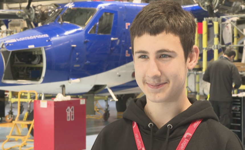 Dmytro Miskov standing in front of an aircraft in Loganair's mechanic workshop.