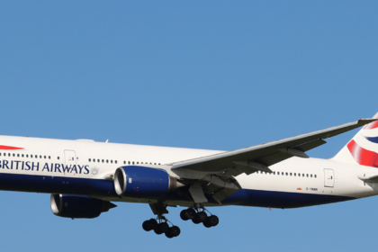 Image shows a British Airways Boeing 777 from the side. The livery is red, white and blue in the style of the UK flag.