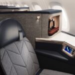 A British Airways Airbus A380 Club suite with sleek black seating featuring a cosy nook for privacy.