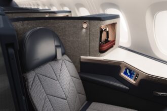 A British Airways Airbus A380 Club suite with sleek black seating featuring a cosy nook for privacy.