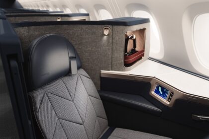 A British Airways Airbus A380 Club suite with sleek black seating featuring a cosy nook for privacy.