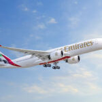 Photograph depicting the Emirates Airbus A350 flying above the clouds during daytime.