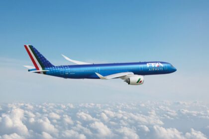 Image shows a blue branded ITA Airways aircraft in a blue sky with white clouds below